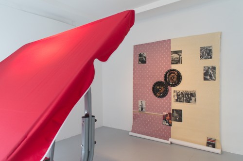 »dispatch the Kennedys« Hollywoodschaukel, Zeitungsausschnitte auf Tapete, Wurfpfeile, 2017, Maße variabel