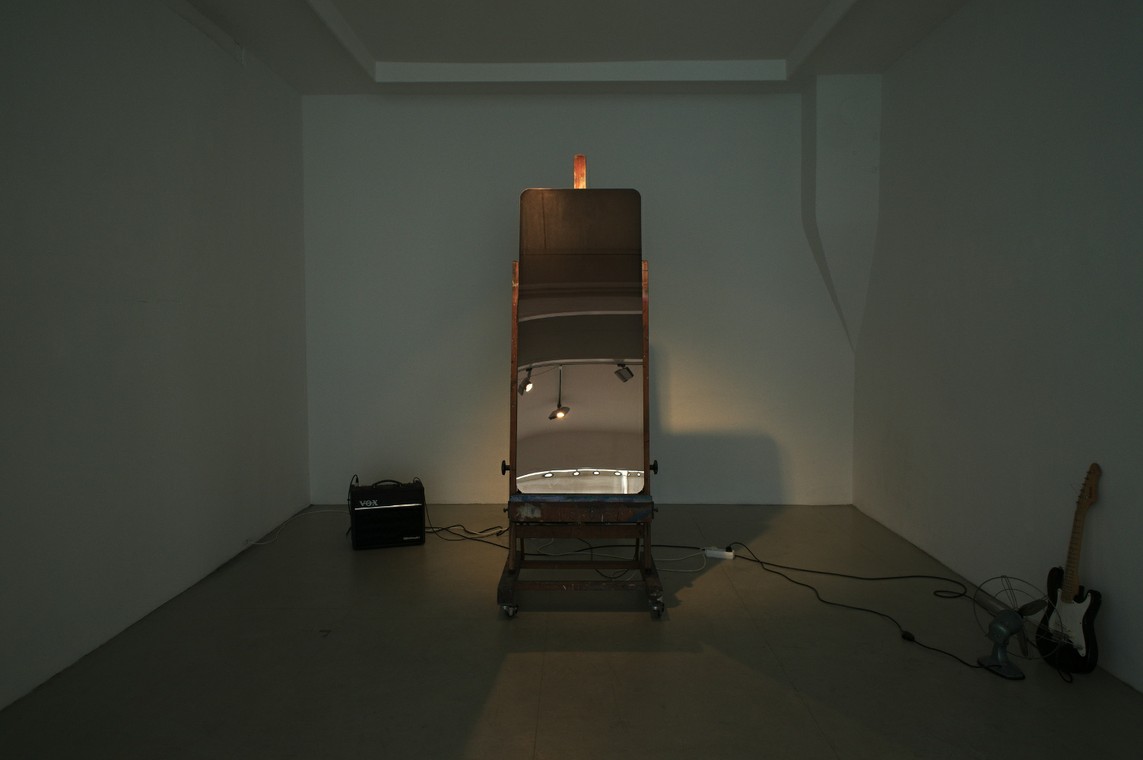 »The Looking Glass« / Edelstahlspiegel, Staffelei (benutzt), Gitarrenverstärker, Gitarre, Ventilator, Nebelmaschine, Elektronik / Maße variabel, 2016